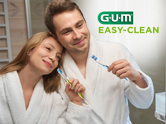 Coppia felice che tiene i loro spazzolini GUM EASY-CLEAN