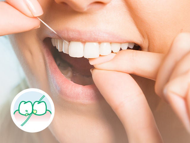 Close-up with a zoom on a smiling mouth while the woman is flossing