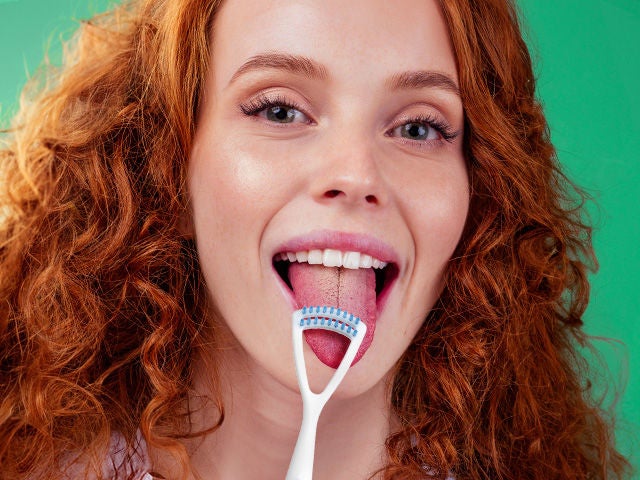 A woman while demonstrating how to clean the tongue with the GUM TONGUE CLEANER